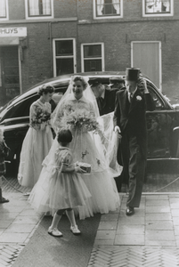 875880 Afbeelding van het bruidspaar P.A. (Piet) Bronius en M.H. (Rie) Noorland, met bruidsmeisjes, dat uitstapt voor ...